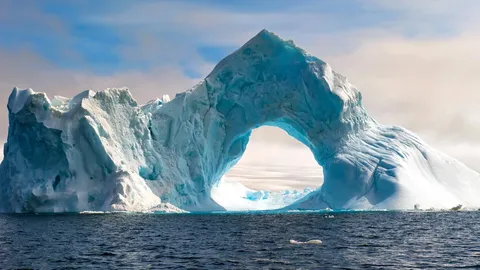 Natural arch carved in an iceberg, Antarctica