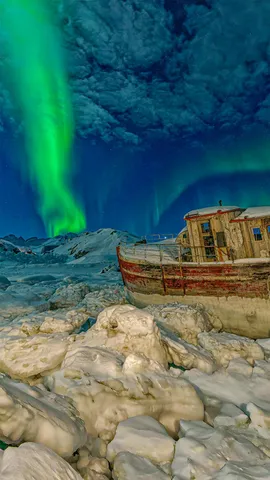 搁浅船只上空的极光，格陵兰岛塔西拉克